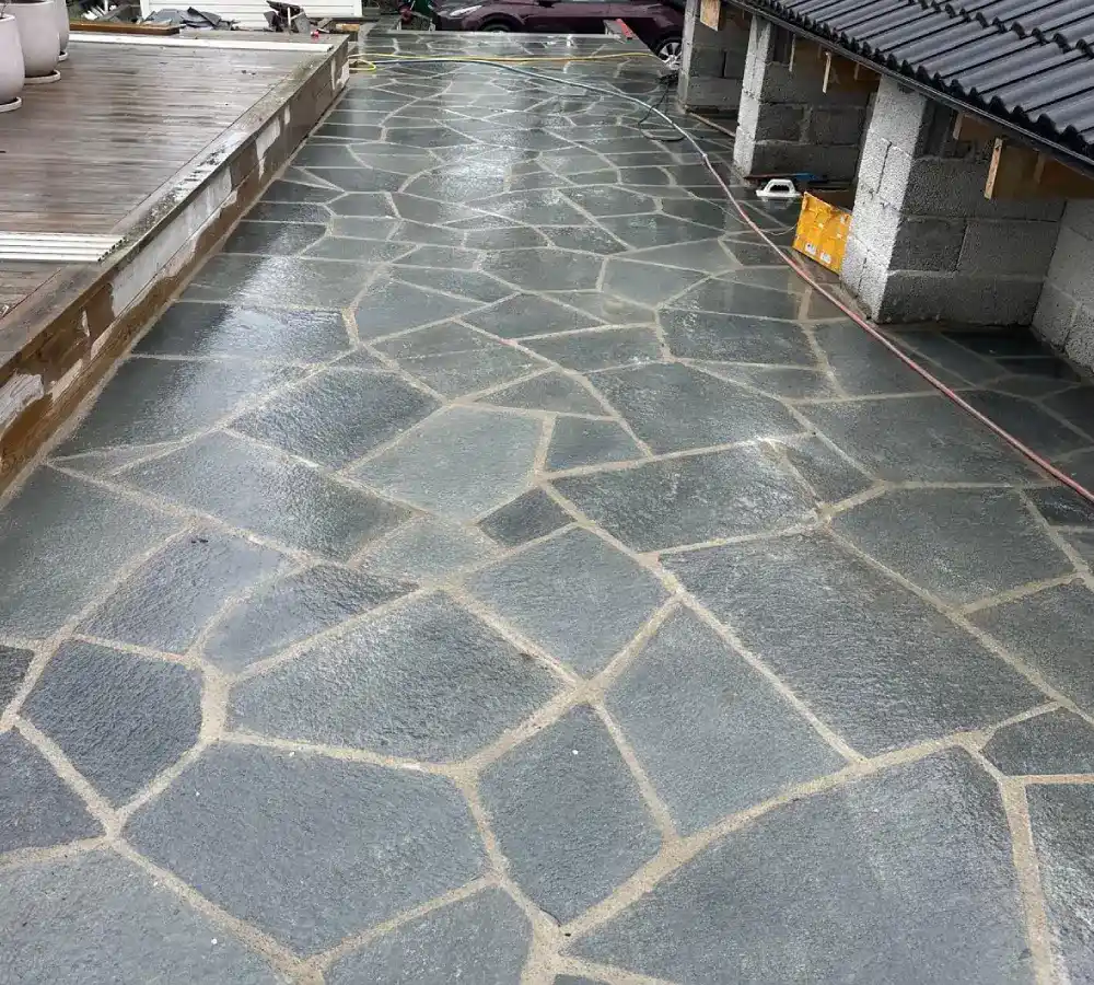 Färdig stenläggning med natursten och fogning vid uteplats